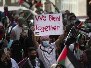 A demonstrator holds a placard in a  march through the city centre in Cape Town, on May 12, 2021 during a protest against Israeli attacks on Palestinians in Gaza as violence escalated between the bitter rivals sparked by unrest at Jerusalem's flashpoint Al-Aqsa Mosque compound