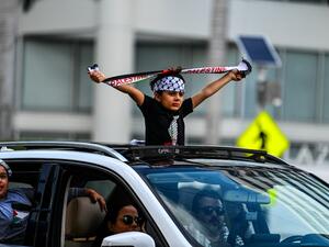 A young demonstrator holds a Palestine scarf during a rally in support of Palestine outside the US Federal Building & Courthouse in Fort Lauderdale