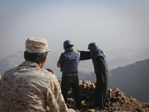 A Yemeni soldier looks at two journalists reporting the event 
