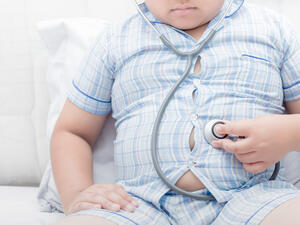 Obese fat boy check stomach by stethoscope.