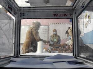 A woman signs a voter registry after casting her ballot at a polling station in Bouchaoui, on the western outskirts of Algeria's capital Algiers, on June 12, 2021 during the 2021 parliamentary elections. Polls opened in Algeria for a parliamentary election overshadowed by a crackdown on a long-running protest movement that has campaigned for a mass boycott. Pro-government parties have urged a big turnout for the "crucial vote" which they hope will restore stability after two years of turmoil since the force