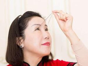 A woman in China with the world's longest eyelashes has broken her own record with an astonishing eight inch eyelash which she says was gifted by Buddha
