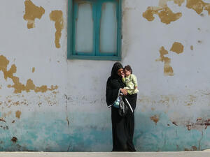A young mother in a black abaya and hijab 