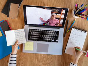 High angle view of video conference with teacher on laptop at home