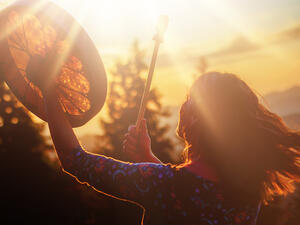 girl playing on shaman frame drum 