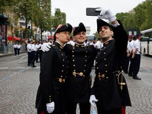Pupils of the Ecole Polytechnique (Special military school of Polytechnique) pose for a picture as preparations are made for the annual Bastille Day military parade on the Champs-Elysees avenue in Paris 