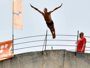 A Bosnian highdiver hurls himself from the 24-metre (79-ft) high Ottoman-era Old Bridge (aka "Stari Most") in the Bosnian town of Mostar during the traditional high diving competition, on July 25, 2021. The "Old Bridge" of Mostar, listed as UNESCO herritage site, dominates the riverside scenery.