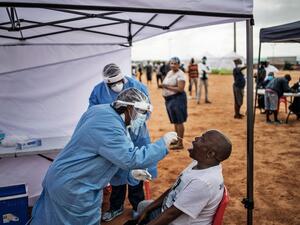 A healthcare worker collecting a swab for a COVID-19 test from a community member. AFP via Getty Images