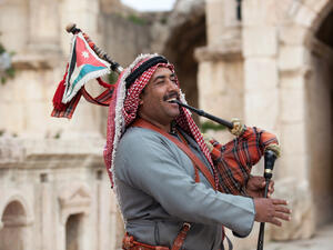  Military bagpipe player perform for tourists at the South Theatre in Gerasa, Jerash