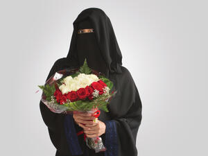 An Arab Saudi Woman holding flower bouquet standing in Saudi Arabia middle east gulf