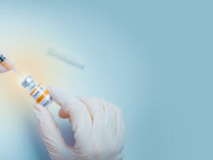 Hand of doctor use a needle syringe to take a shot from vaccine vial