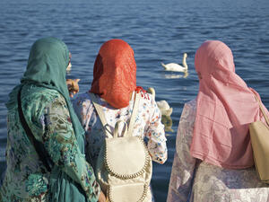 Women By The Lake Looking At Wildlife In The Summer