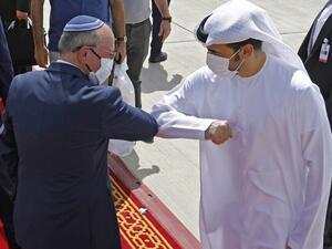 National Security Adviser Meir Ben-Shabbat elbow bumps with an Emirati official ahead of boarding the plane before leaving Abu Dhabi