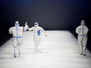 Models wearing outfits inspired by healthcare workers walk down the runway as part of the 'Heroes in Harm's Way' collection during the China Fashion Week in Beijing.