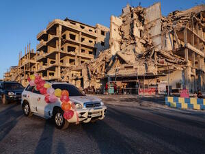 A wedding convoy drives past Abu Ali's cafe