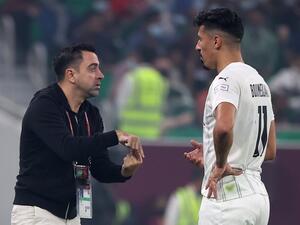 Sadd's coach Xavi (L) speaks to Sadd's forward Baghdad Bounedjah (R) during the Amir Cup final football match between Al-Sadd and Al-Rayyan at the Al-Thumama Stadium in the capital Doha on October 22, 2021. (Photo by KARIM JAAFAR / AFP)