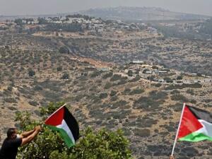Palestinian demonstrators wave flags during a protest