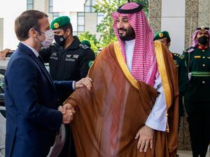 Macron (L) is greeted by Mohammed bin Salman 