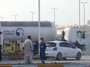 Men stand outside a storage facility of oil giant ADNOC 