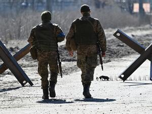 Ukrainian soldiers walk on the front line 