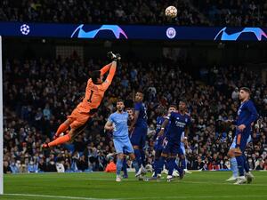 Real Madrid's Belgian goalkeeper Thibaut Courtois jumps to stop the ball during the UEFA Champions League semi-final first leg football match between Manchester City and Real Madrid, at the Etihad Stadium, in Manchester, on April 26, 2022. (Photo by Paul ELLIS / AFP)