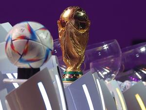 The FIFA World Cup trophy and the official 2022 World Cup ball called Al-Rihla, which means "the journey" in Arabic, are seen on stage during the draw for the 2022 World Cup in Qatar at the Doha Exhibition and Convention Center on April 1, 2022. (Photo by KARIM JAAFAR / AFP) The FIFA World Cup trophy and the official 2022 World Cup ball called Al-Rihla, which means "the journey" in Arabic, are seen on stage during the draw for the 2022 World Cup in Qatar at the Doha Exhibition and Convention Center on April 1, 2022. (Photo by KARIM JAAFAR / AFP)