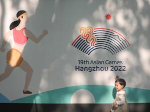 A child plays in front of a wall with images of the 2022 Asian Games in Hangzhou, in China's eastern Zhejiang province on May 8, 2022. China's ambitions to be a global sporting hub took a heavy blow as the May 6, 2022 postponement of this year's Asian Games further isolated a country already cut off by its hardline zero-Covid strategy. (Photo by AFP) / CHINA OUT A child plays in front of a wall with images of the 2022 Asian Games in Hangzhou, in China's eastern Zhejiang province on May 8, 2022. China's ambitions to be a global sporting hub took a heavy blow as the May 6, 2022 postponement of this year's Asian Games further isolated a country already cut off by its hardline zero-Covid strategy. (Photo by AFP) / CHINA OUT