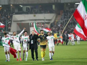 Iran's players celebrate with their fans after qualifying for the 2022 Qatar World Cup after their win against Iraq in the Asian Qualifiers football match at the Azadi Sports Complex in the capital Tehran, on January 27, 2022. (Photo by Atta KENARE / AFP)