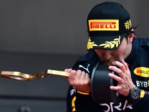 Red Bull Racing's Mexican driver Sergio Perez kisses his trophy on the podium after winning the Monaco Formula 1 Grand Prix at the Monaco street circuit in Monaco, on May 29, 2022. (Photo by SEBASTIEN BOZON / AFP)