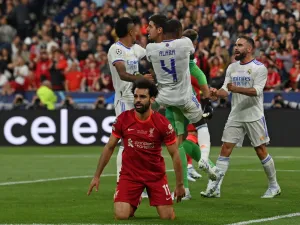 Real Madrid's teammates congratulate Real Madrid's Belgian goalkeeper Thibaut Courtois (rear C) after he saved a shot by Liverpool's Egyptian midfielder Mohamed Salah reacting on the foreground during the UEFA Champions League final football match between Liverpool and Real Madrid at the Stade de France in Saint-Denis, north of Paris, on May 28, 2022. (Photo by Paul ELLIS / AFP)