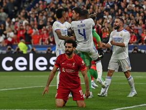Real Madrid's teammates congratulate Real Madrid's Belgian goalkeeper Thibaut Courtois (rear C) after he saved a shot by Liverpool's Egyptian midfielder Mohamed Salah reacting on the foreground during the UEFA Champions League final football match between Liverpool and Real Madrid at the Stade de France in Saint-Denis, north of Paris, on May 28, 2022. (Photo by Paul ELLIS / AFP) Real Madrid's teammates congratulate Real Madrid's Belgian goalkeeper Thibaut Courtois (rear C) after he saved a shot by Liverpool's Egyptian midfielder Mohamed Salah reacting on the foreground during the UEFA Champions League final football match between Liverpool and Real Madrid at the Stade de France in Saint-Denis, north of Paris, on May 28, 2022. (Photo by Paul ELLIS / AFP)