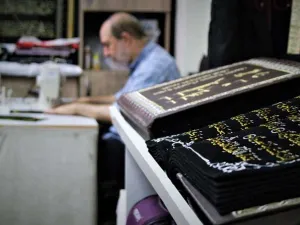 أنامل خطاط سوري تبدع في نقش القرآن الكريم