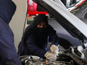 Ghada Ahmed (R) works on a car in Saudi Arabia