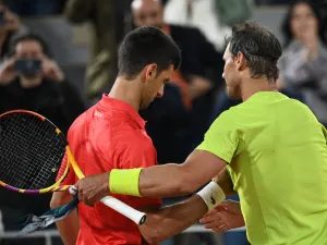 Spain's Rafael Nadal (R) shakes hands with Serbia's Novak Djokovic (L) after winning at the end of their men's singles match on day ten of the Roland-Garros Open tennis tournament at the Court Philippe-Chatrier in Paris early June 1, 2022. (Photo by Anne-Christine POUJOULAT / AFP)