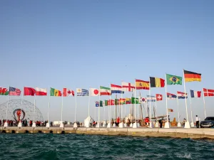 A general view shows flags of the qualified countries for the 2022 World Cup in the Qatari capital Doha during a flag-raising ceremony of the last remaining countries to qualify, on June 16, 2022. (Photo by Mustafa ABUMUNES / AFP)