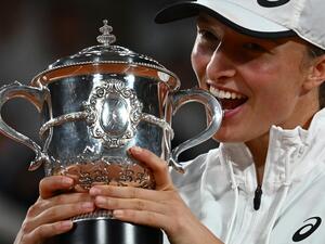 Poland's Iga Swiatek poses with the trophy after winning against US' Coco Gauff at the end of their women's single final match on day fourteen of the Roland-Garros Open tennis tournament at the Court Philippe-Chatrier in Paris on June 4, 2022. Iga Swiatek cruised to her second French Open title by dominating teenager Coco Gauff in the final as the world number one claimed her 35th successive victory. (Photo by Anne-Christine POUJOULAT / AFP) Poland's Iga Swiatek poses with the trophy after winning against US' Coco Gauff at the end of their women's single final match on day fourteen of the Roland-Garros Open tennis tournament at the Court Philippe-Chatrier in Paris on June 4, 2022. Iga Swiatek cruised to her second French Open title by dominating teenager Coco Gauff in the final as the world number one claimed her 35th successive victory. (Photo by Anne-Christine POUJOULAT / AFP)