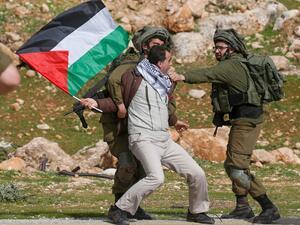 A Palestinian clutched by Israeli soldiers 