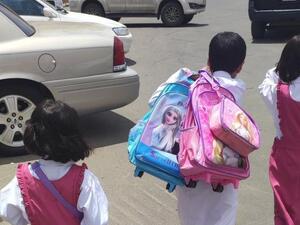 الطفل مشعل الشهراني يحمل حقائب شقيقته