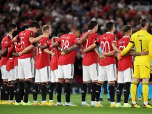Manchester United players pause for a silence following the death of Queen Elizabeth II, ahead of the UEFA Europa League Group E football match between Manchester United and Real Sociedad, at Old Trafford stadium, in Manchester, on September 8, 2022. (Photo by Oli SCARFF / AFP)