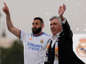 Real Madrid's French forward Karim Benzema (L) and Real Madrid's Italian coach Carlo Ancelotti wave to supporters on the Plaza Cibeles square in Madrid, after Real Madrid CF won the Spanish League football match against RCD Espanyol on April 30, 2022. (Photo by OSCAR DEL POZO / AFP)