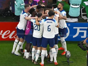 England's players celebrate after England's forward #11 Marcus Rashford scored their team's first goal during the Qatar 2022 World Cup Group B football match between Wales and England at the Ahmad Bin Ali Stadium in Al-Rayyan, west of Doha on November 29, 2022. (Photo by Antonin THUILLIER / AFP)