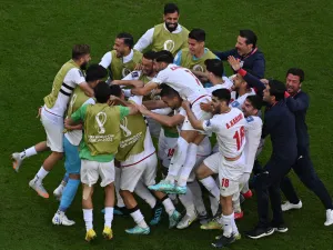 Iran's players celebrate after scoring the opening goal during the Qatar 2022 World Cup Group B football match between Wales and Iran at the Ahmad Bin Ali Stadium in Al-Rayyan, west of Doha on November 25, 2022. (Photo by Antonin THUILLIER / AFP)