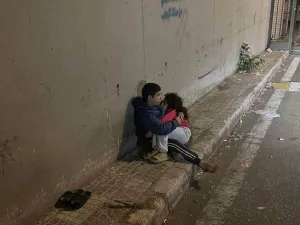 فتى لبناني يحتضن أخته الصغيرة بعد ليلة شديدة البرودة في شارع بالعاصمة بيروت.