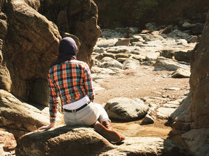 فتاة تجلس على الصخور في مدينة البتراء الاثرية جنوب الاردن