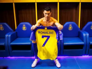 A handout picture released by Saudi Arabia's al-Nassr football club shows Al-Nassr's new Portuguese forward Cristiano Ronaldo holding the club's number seven jersey ahead of his unveiling ceremony at the Mrsool Park Stadium in the Saudi capital Riyadh on January 3, 2023. (Photo by Jorge Ferrari / Al Nassr Football Club / AFP)
