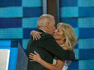 الرئيس جو بايدن وزوجته الدكتورة جيل بايدن يتعانقان على المنصة في فيلادلفيا