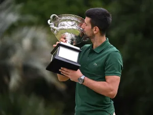 Serbia's Novak Djokovic poses with the Norman Brookes Challenge Cup trophy in Melbourne on January 30, 2023, after winning the Australian Open tennis tournament's mens' singles final against Greece's Stefanos Tsitsipas. (Photo by WILLIAM WEST / AFP) 