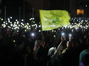 أنصار حزب الله يحملون هواتفهم ويلوحون بعلم الحزب