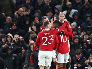 Manchester United's Brazilian midfielder Antony (R) celebrates with teammates after scoring their second goal during the UEFA Europa league round of 16 first leg football match between Manchester United and Real Betis at Old Trafford stadium in Manchester, north-west England, on March 9, 2023. (Photo by DARREN STAPLES / AFP)