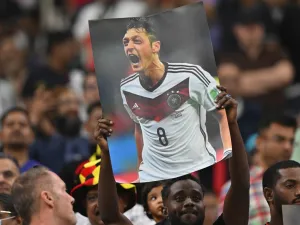 A supporter holds up a poster of German football player Mesut Ozil during the Qatar 2022 World Cup Group E football match between Costa Rica and Germany at the Al-Bayt Stadium in Al Khor, north of Doha on December 1, 2022. (Photo by Glyn KIRK / AFP)